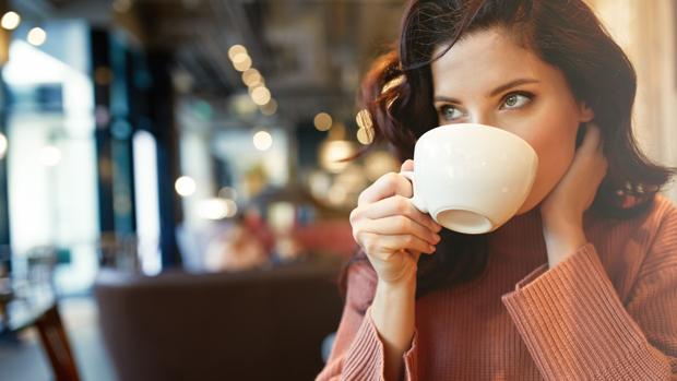 Una joven bebe una taza de café