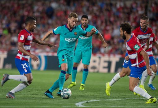 El defensa isleño Germán trata de frenar a Rakitic.