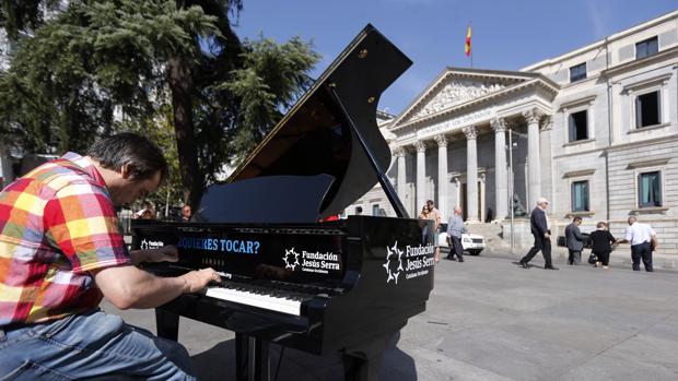 Un músico ofrece un improvisado concierto a las puertas del Congreso