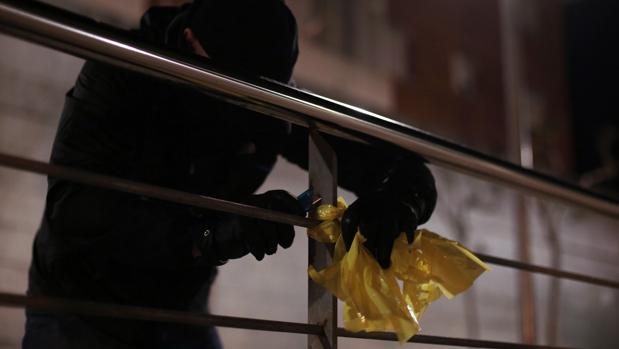 Miembros de los GDR, Grupos de Defensa y Resistencia, a cara tapada para evitar represalias, retiran lazos amarillos.