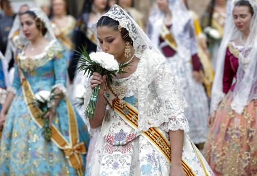 Una fallera besa sus flores en el momento de expresar los deseos
