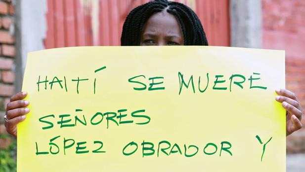 Una inmigrante haitiana sujeta una bandera en una protesta en Tapachula, México