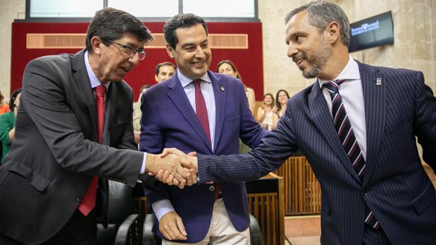 Juan Marín y Juan Bravo se felicitan bajo la mirada de Juanma Moreno