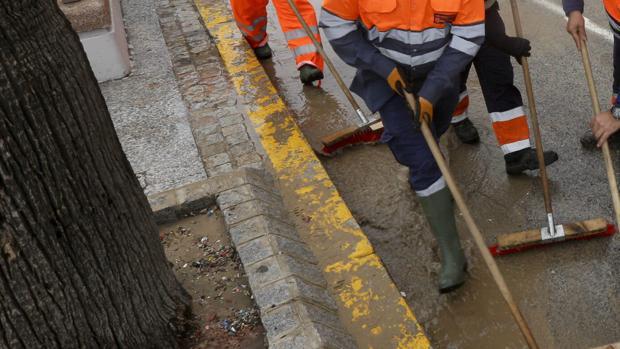 Varios operarios limpian la zona de los bordillos en Cádiz
